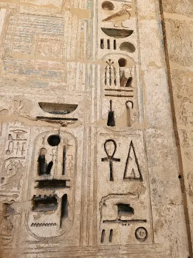 Ancient Egyptian hieroglyphs including an ankh carved into temple stone